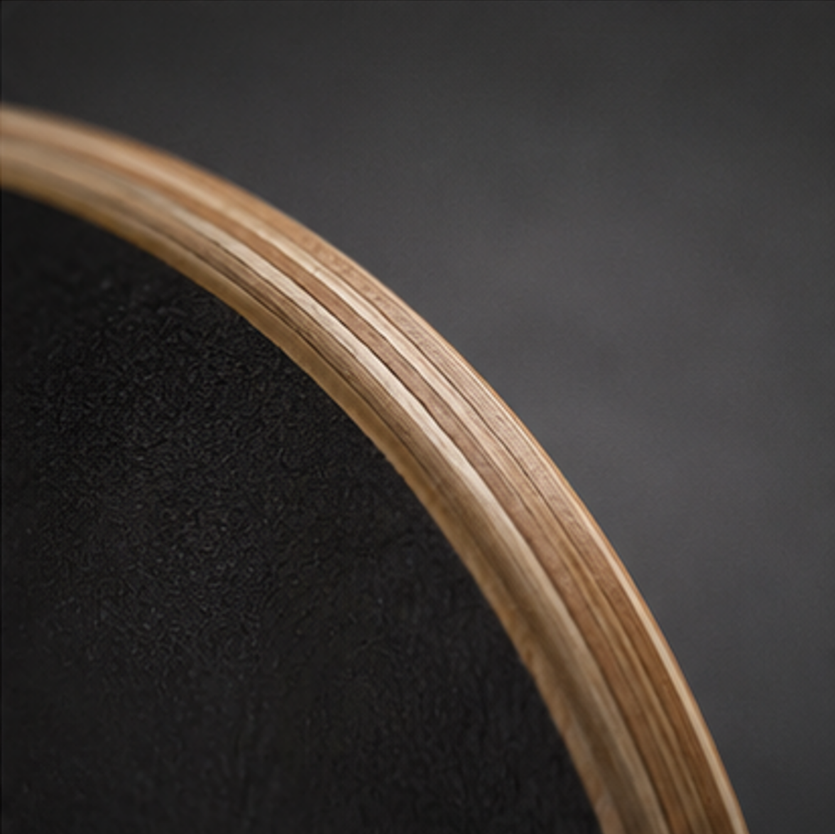 Close-up of maple skateboard deck edge showing layered wood construction